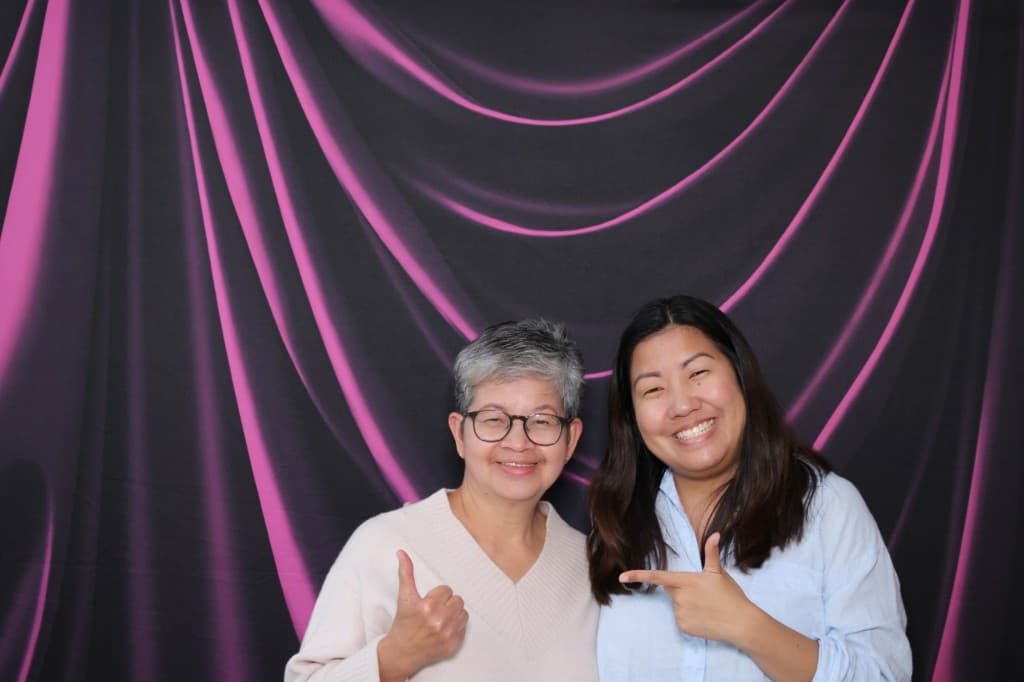 Two guests smiling at a celebration photo booth